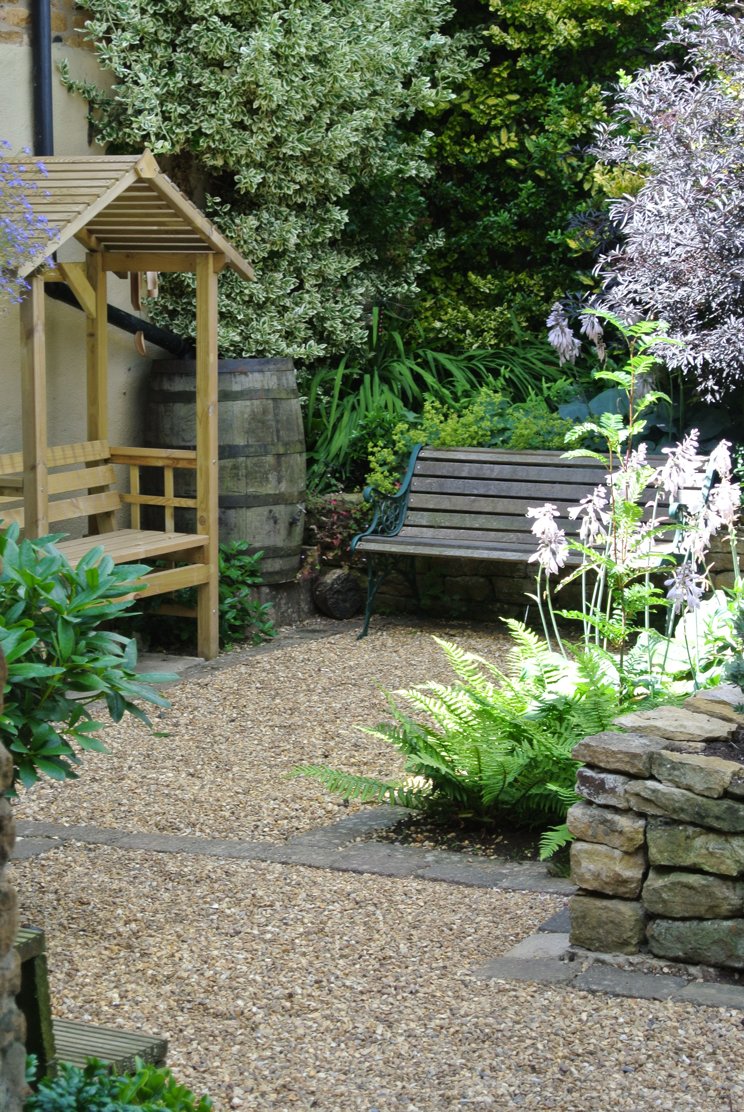 Small cottage garden design for family in Northampton - view of shady seating area